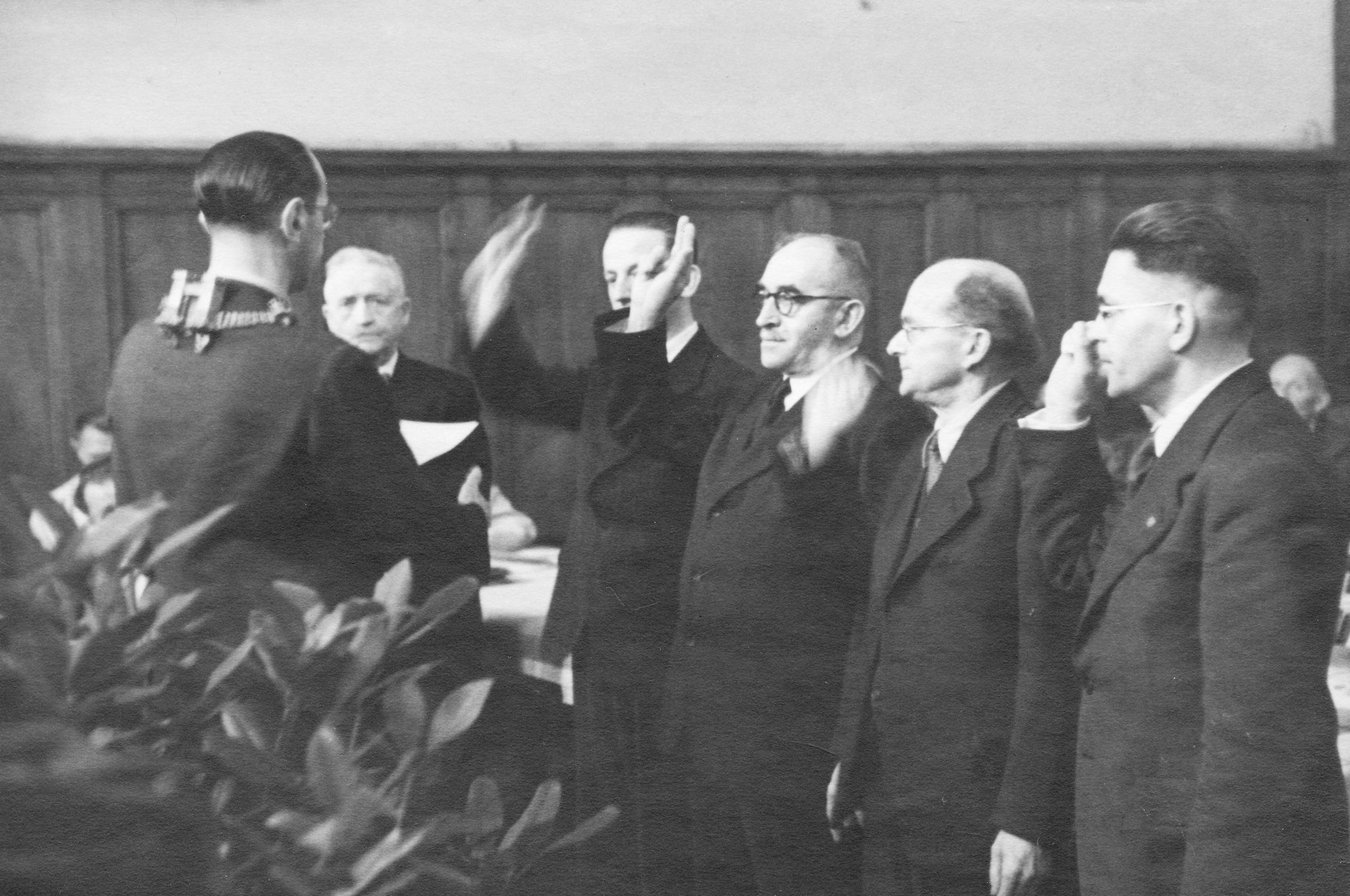 Oberbürgermeister Hans Heinrich Redlhammer bei der Vereidigung der Stadträte Philipp Holl, Heinrich Roos, Eugen Dengel, Johannes Maaß und Georg Buch (von l. nach r.) in der Aula der damaligen Gewerbeschule in der Wellritzstraße am 12. August 1946